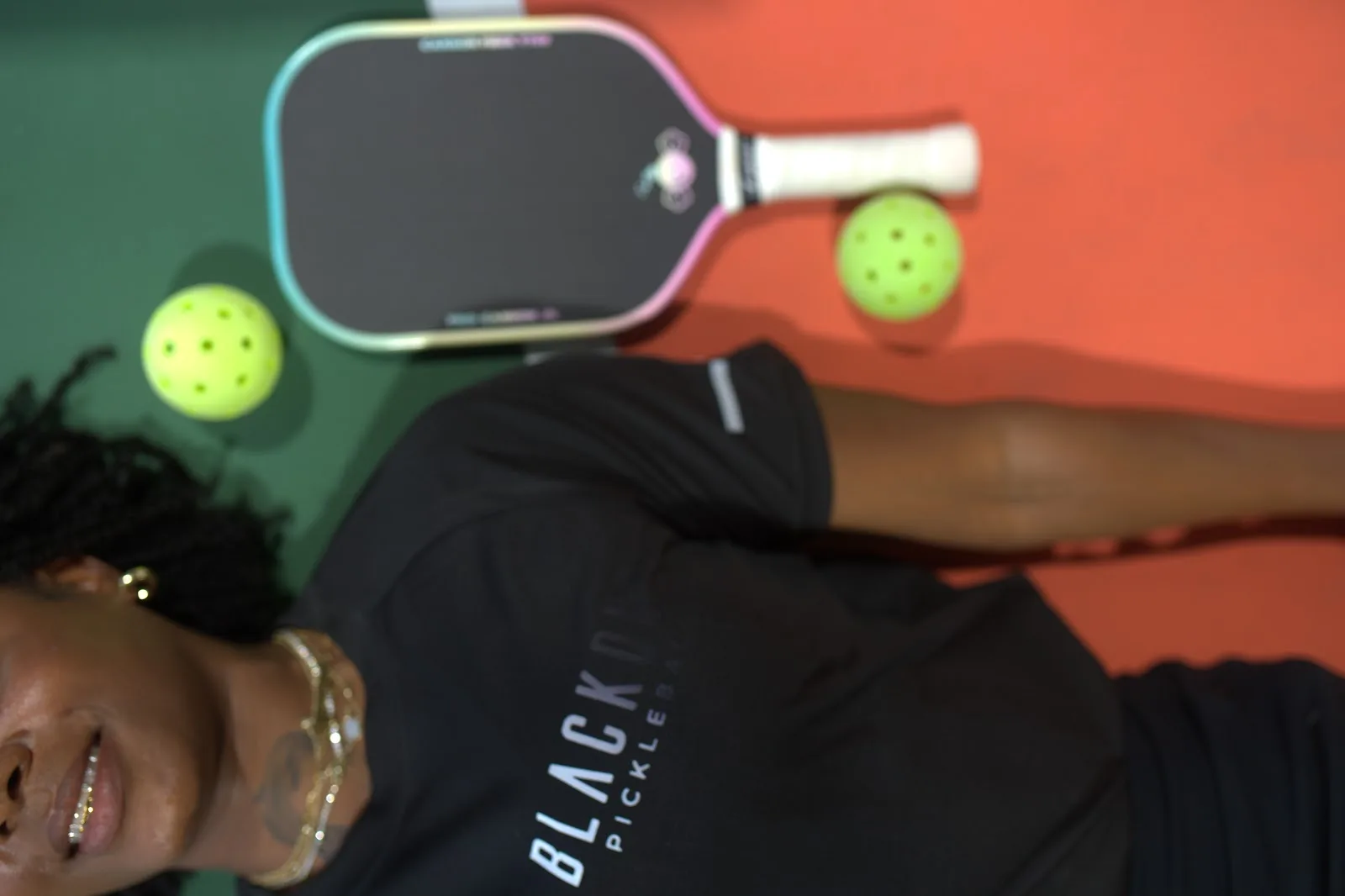 Creative close-up — athlete with paddle and pickleballs in Blackout long-sleeve